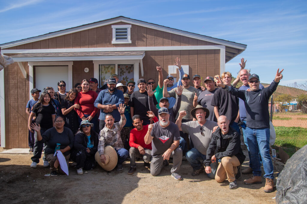 mission team standing in front of the house they built 